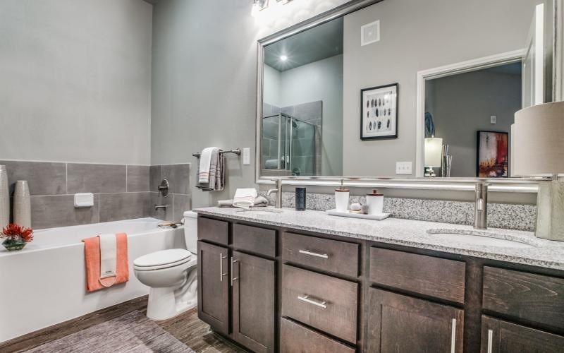 a bathroom with a large mirror, toilet and a tub