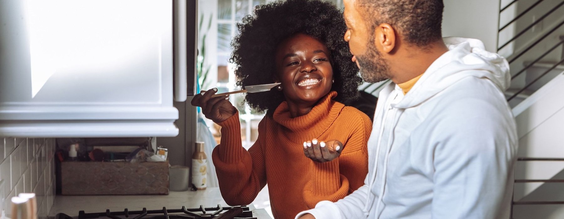 a man and a woman cooking on a gas stove top